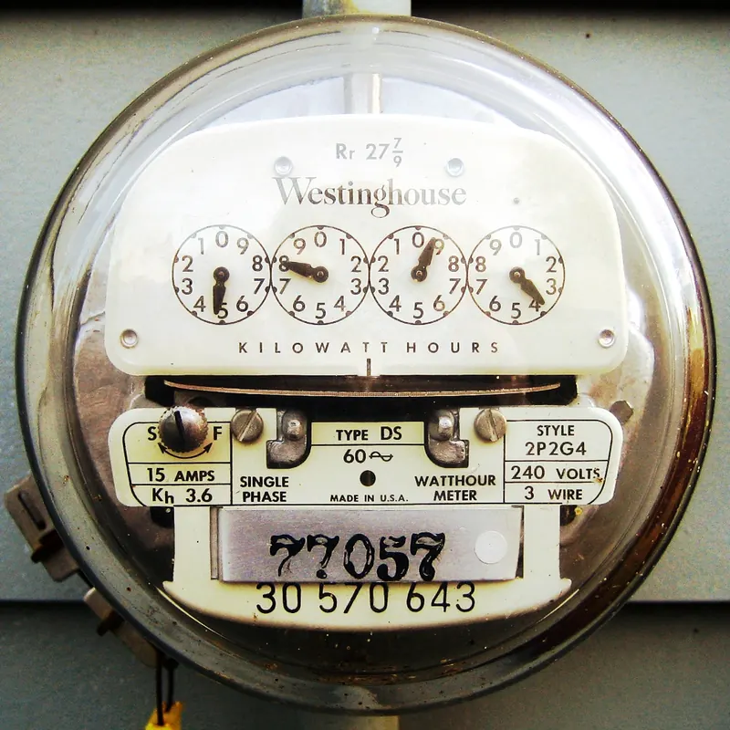 Photo of an analog residential electric meter with kilowatt-hour dials, rated 240 volts